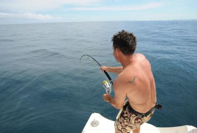 Un pêcheur plaisancier remonte sa prise.